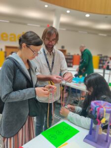 Jake showing visitors how to use a braiding loom