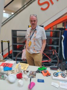 Adrian standing in front of a bike and behind the mcqn table , which has a selection of mcqn products on it.